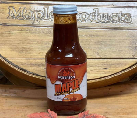 Maple BBQ Sauce Bottle of Patterson's Maple Barbecue Sauce on a wooden background, featuring the text "Refrigerate After Opening." Ideal for enhancing grilled dishes with a sweet maple flavor.